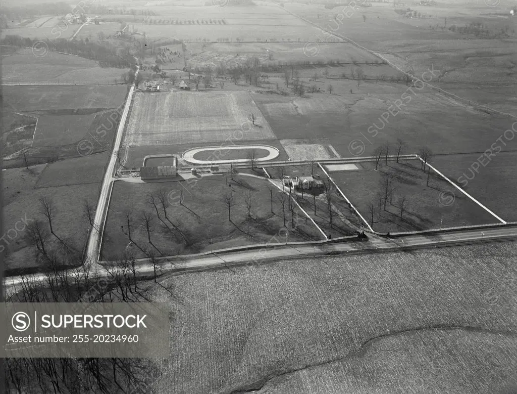 Aerial view of Richmond, Indiana showing country home of horse fancier Roy Campbell with jogging track behind house near stables, off US Route 27