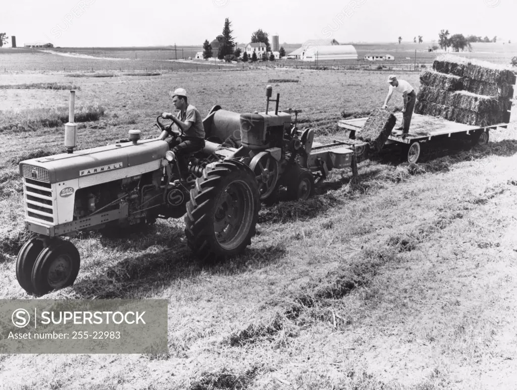 Farmer baling alfalfa crop in a field, Illinois, USA