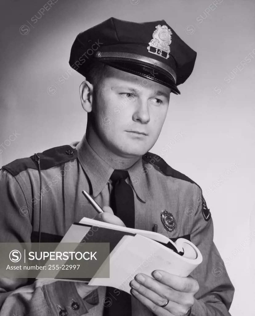 Close-up of a policeman writing on a note pad