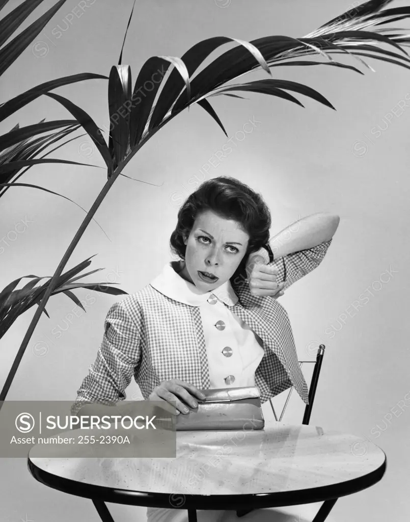 Mid adult woman listening to her wristwatch and looking impatient