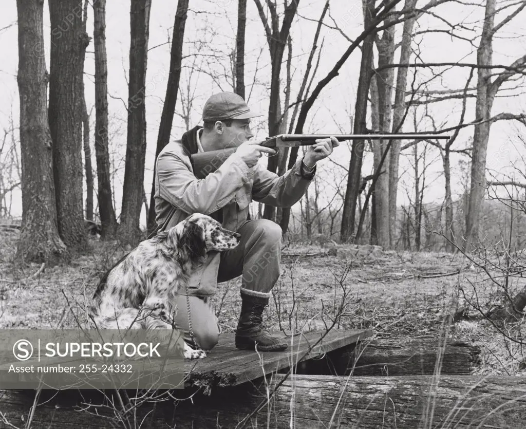 Male hunter aiming with his rifle