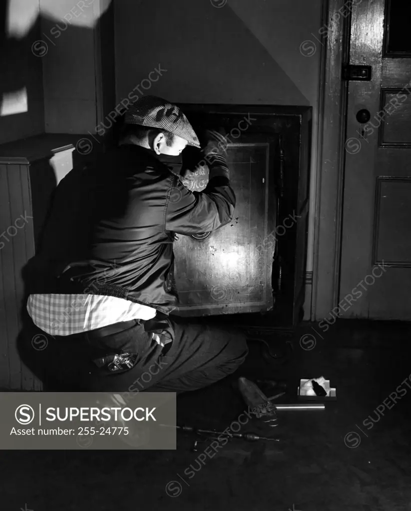 Burglar opening safe