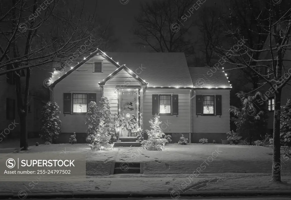 Vintage Photograph. Small house with lights and cut out figures, decorations for the Christmas Holidays