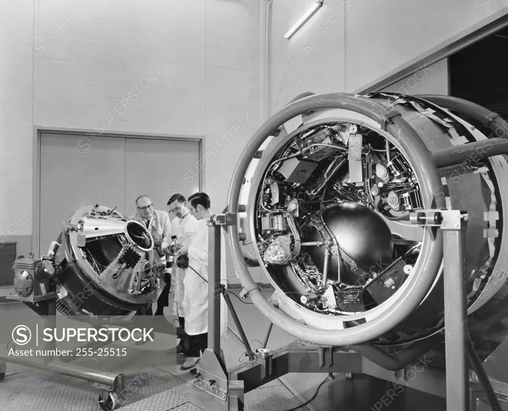 Three scientists working on satellites in a laboratory, GE Space Technology Labs, Valley Forge, Pennsylvania, USA