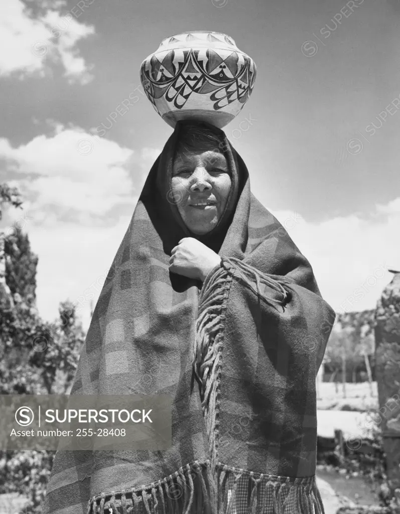 Jemez woman standing with a pottery on her head