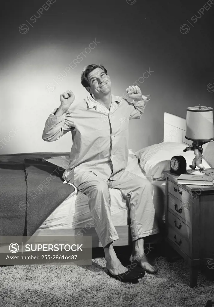 Vintage Photograph. Man in pajamas stretching after waking up. Frame 2