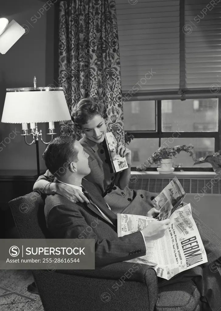 Vintage Photograph. Couple sitting in chair reading. Frame 3