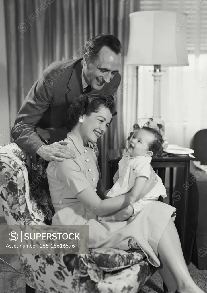 Vintage Photograph. Kevin Allen Connor. Nellie Jane Cannon. Model Released. Parents in living room holding and looking at baby. Frame 4