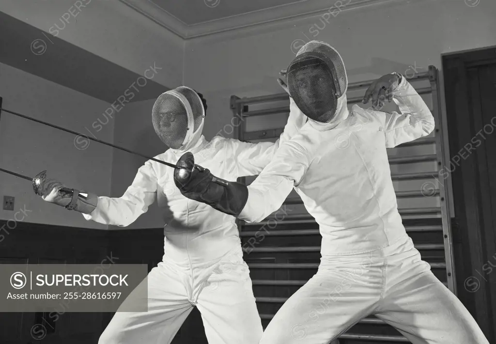 Vintage Photograph. Lawrence M. Goldstein. Edward G Sebo. Model Released. Men in fencing uniform striking with saber.