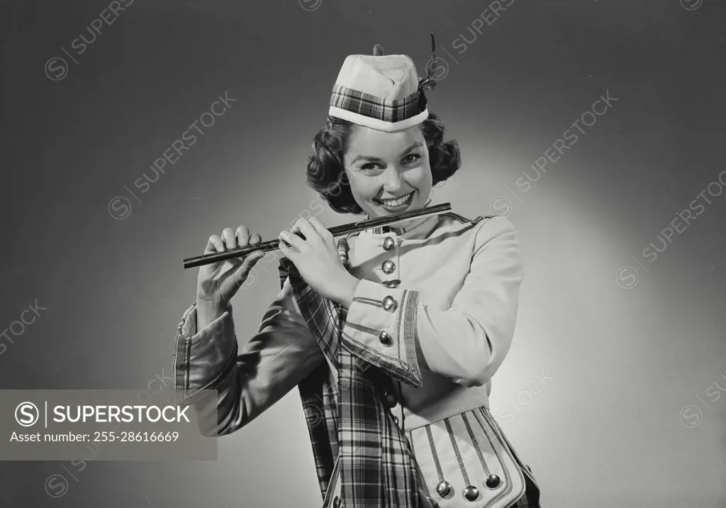 Vintage Photograph. Woman in traditional Scottish clothing playing the flute. Frame 1