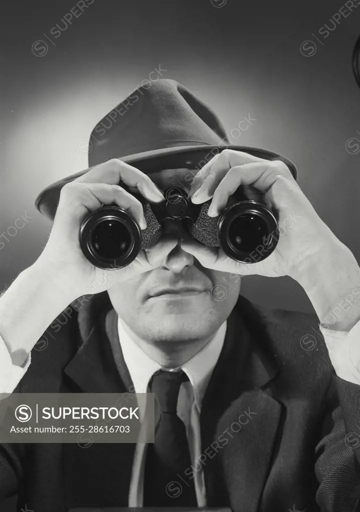 Vintage Photograph. Man wearing hat and looking through binoculars. Frame 2