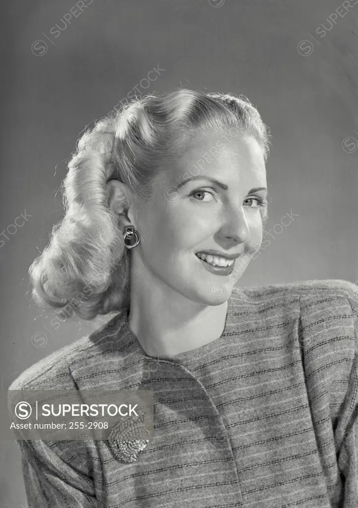 Vintage Photograph. Smiling blonde woman with curled hair wearing striped wool top with brooch