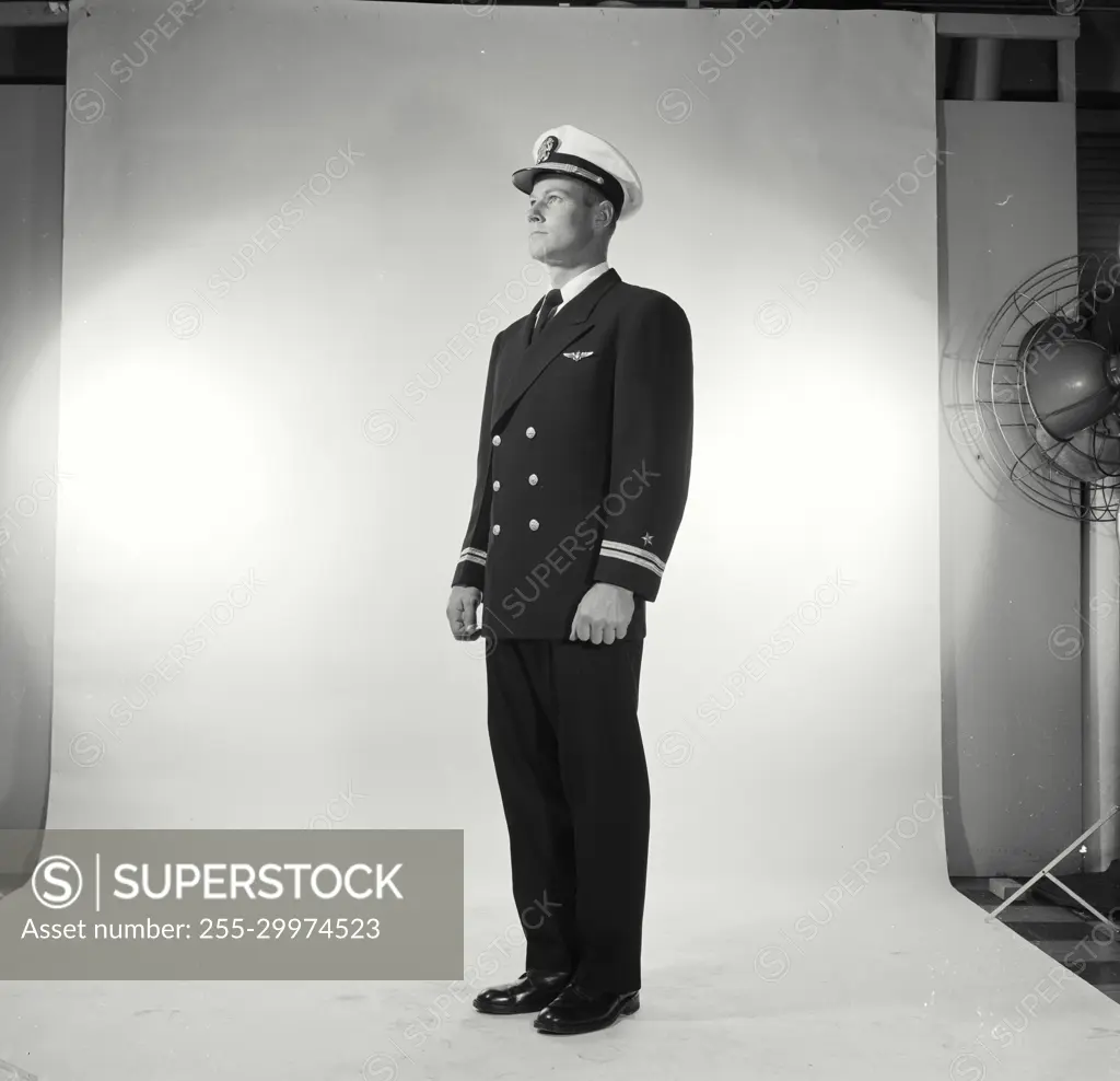 Vintage Photograph. Soldier in full dress stands at attention in studio portrait.