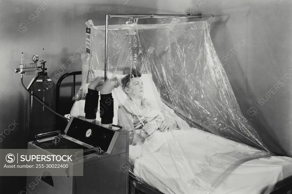 Vintage Photograph. Woman patient in an oxygen tent.