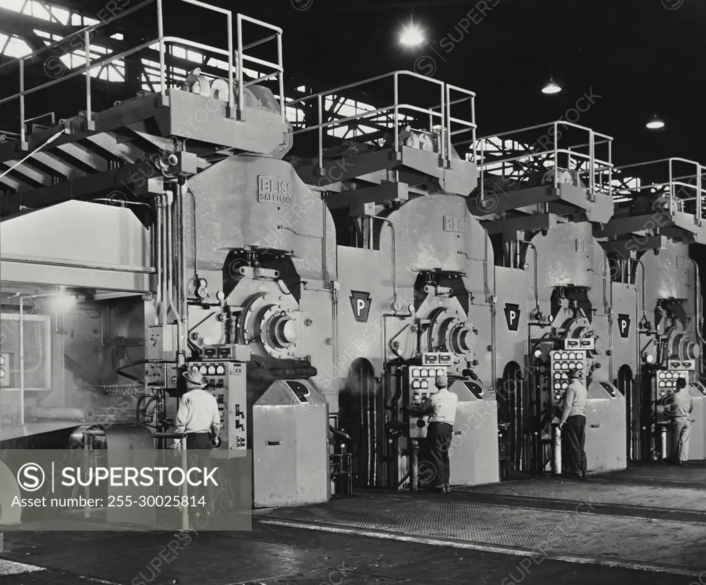 Vintage Photograph. Cold rolled steel sheets roll through for stand tandem mill.