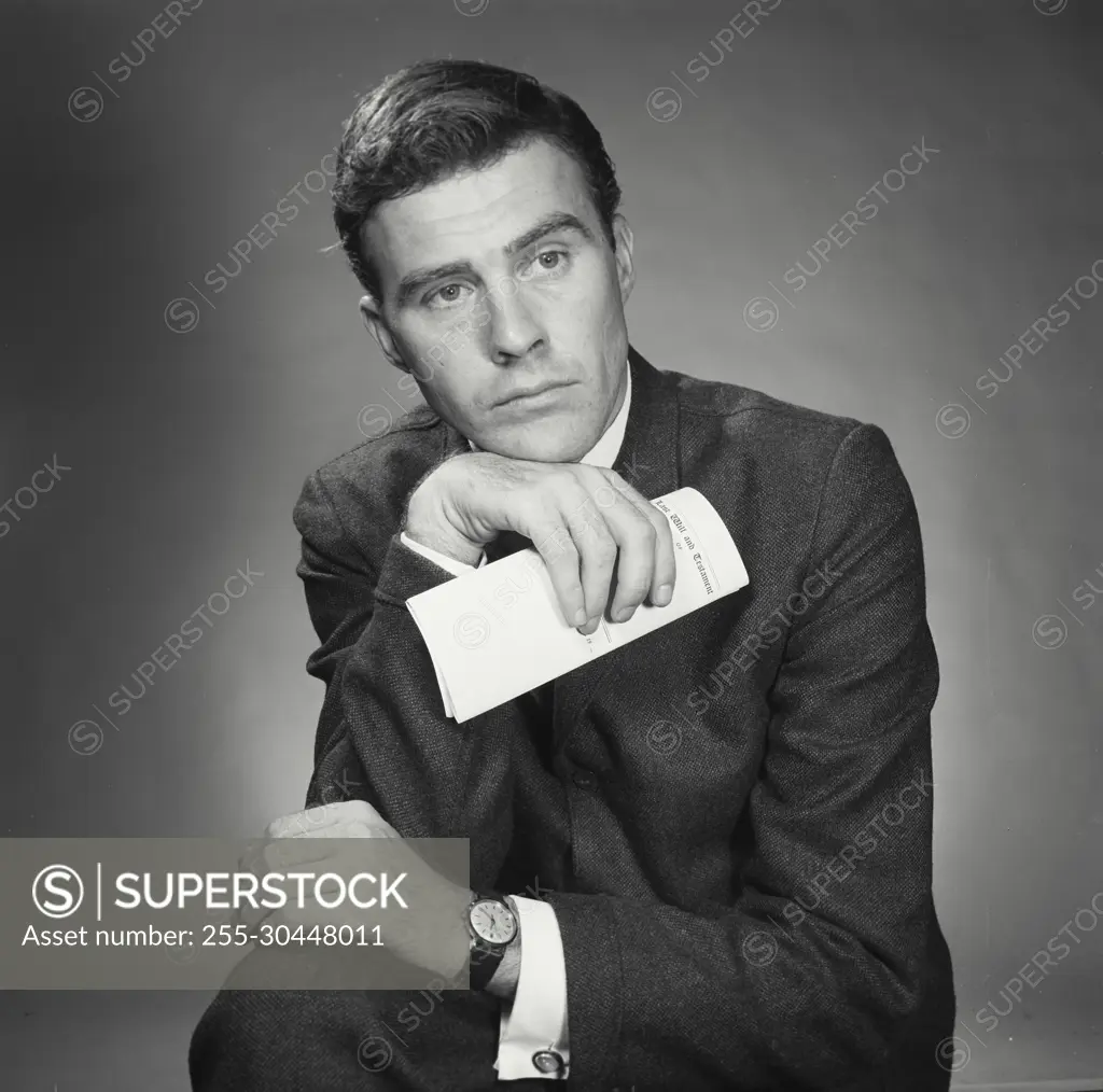 Vintage Photograph. Portrait of man in business attire with document. Frame 1