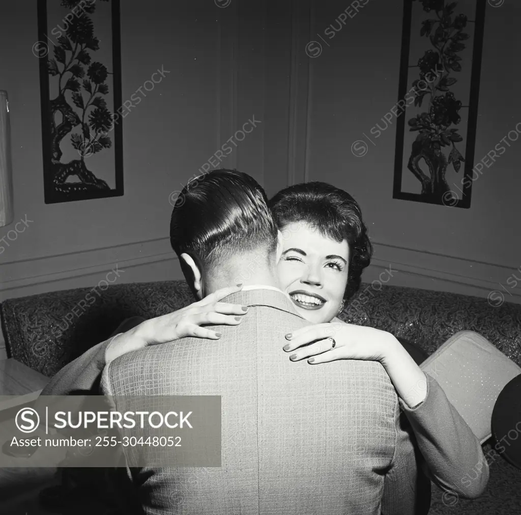 Vintage Photograph. Woman winking at camera while hugging man. Frame 2