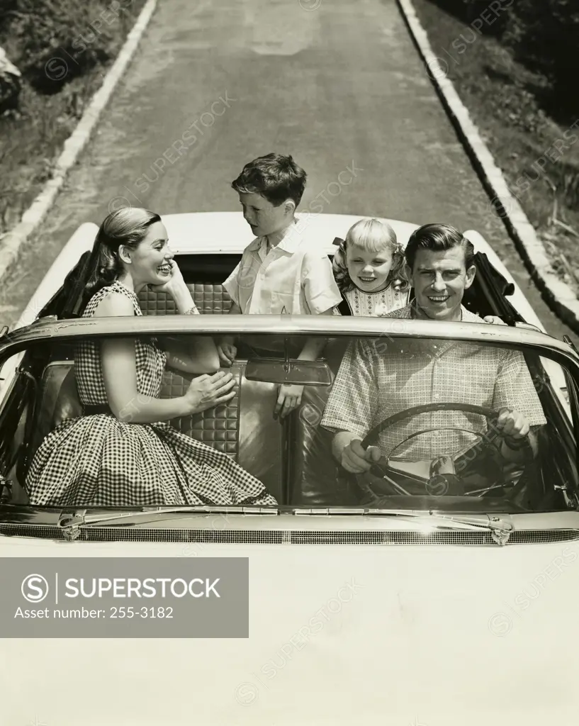 High angle view of parents and their children traveling in a car