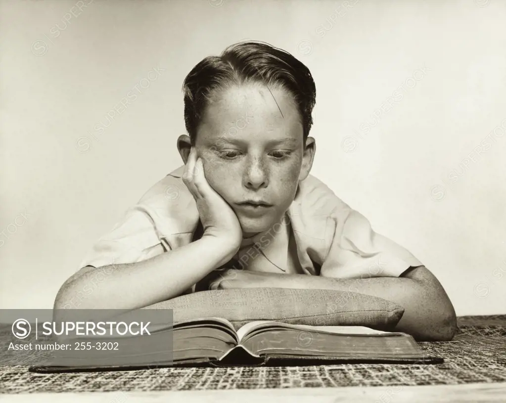 Close-up of a boy reading a book