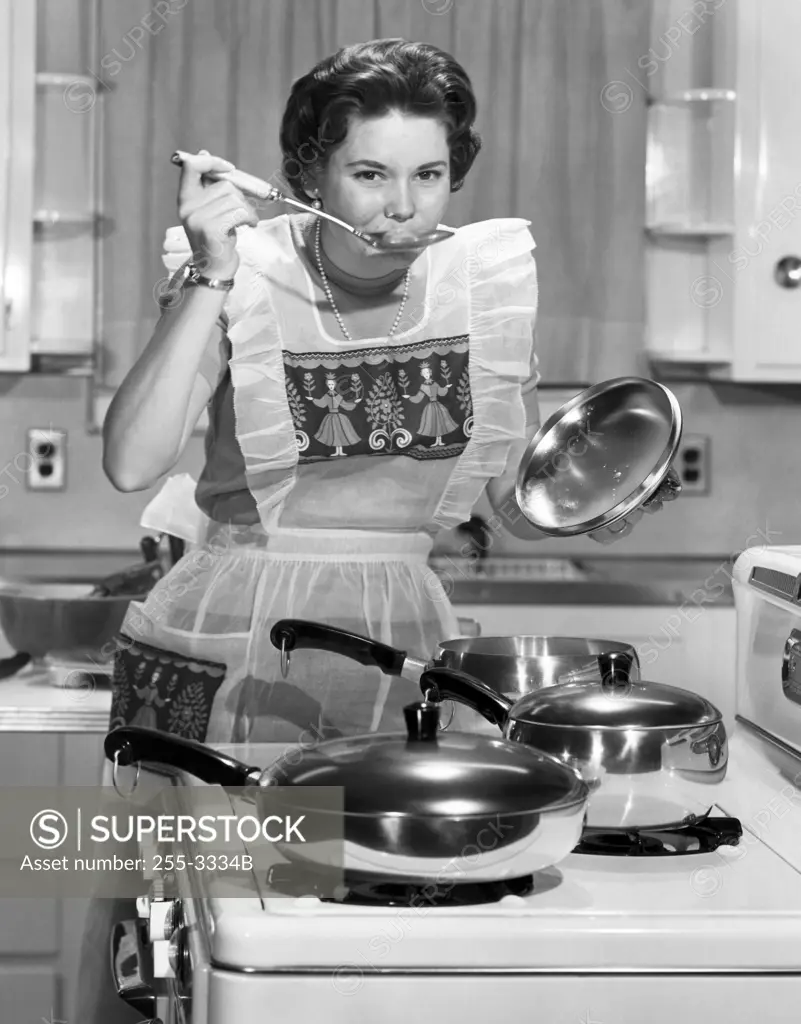 Young woman tasting food with a ladle