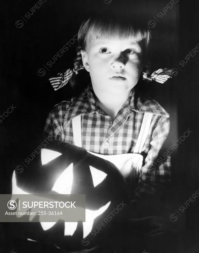 Close-up of a girl with illuminated jack o' lantern