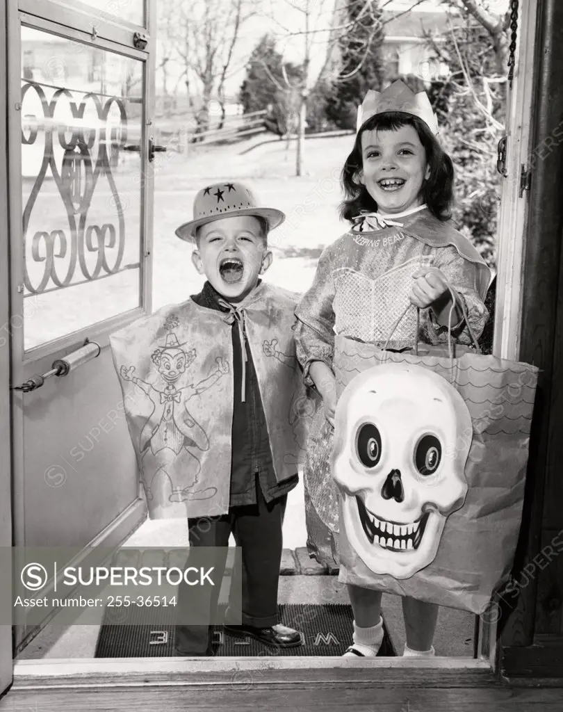 Portrait of a boy and a girl wearing Halloween costumes for trick or treating