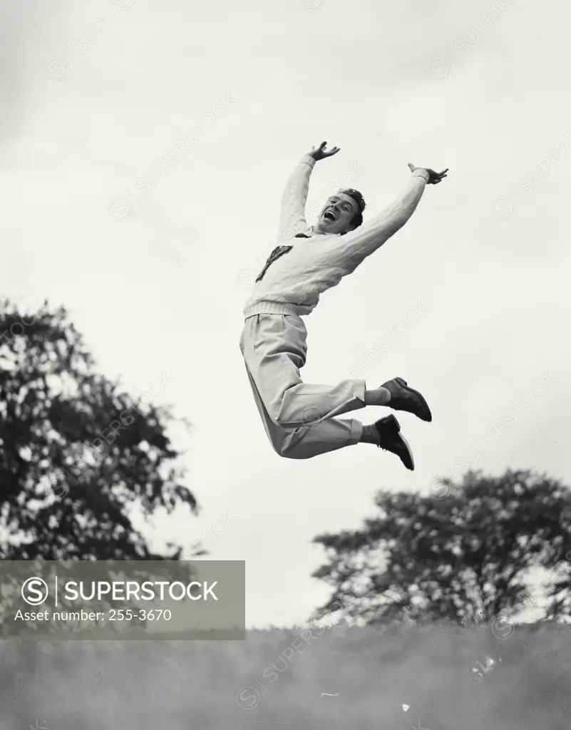 Vintage photograph. Man jumping in the air while pushing arms and legs back