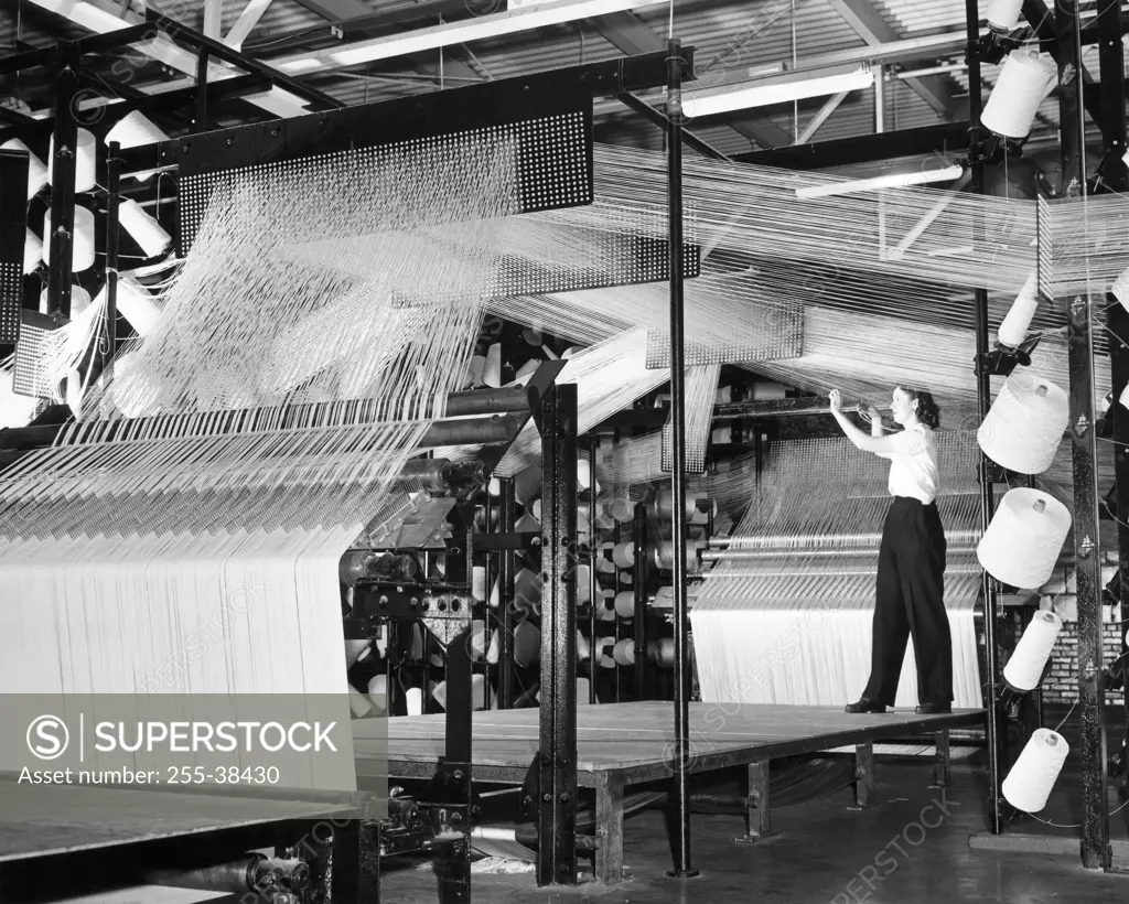 Side profile of a manual worker working in a creel room of a textile factory