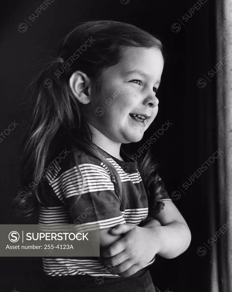 Girl seated near window with hands folded