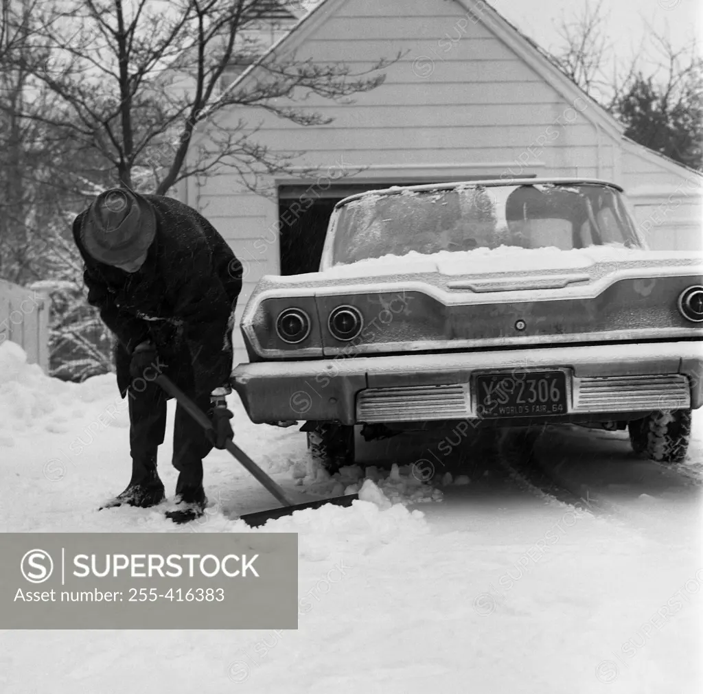 Man cleaning snow around car