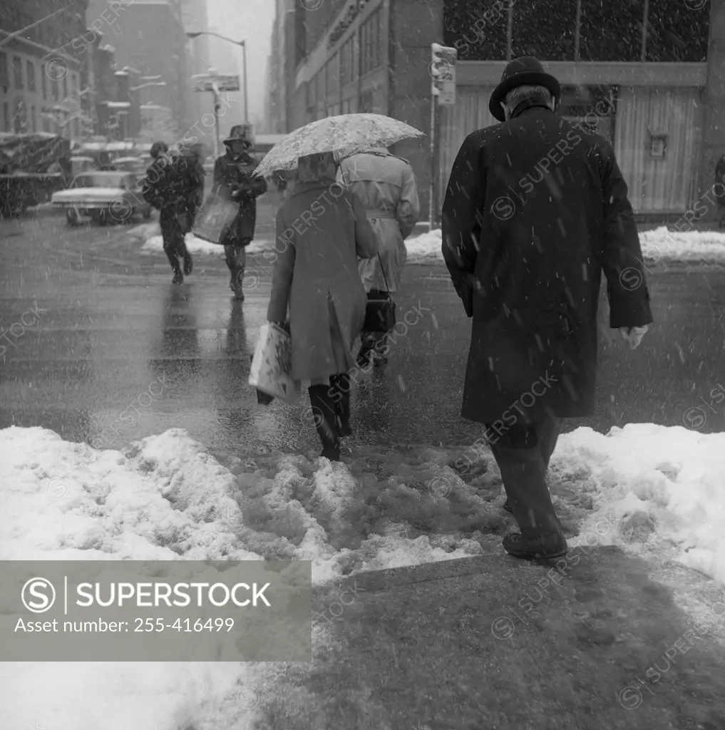 USA, New York City,  pedestrians walking through snow