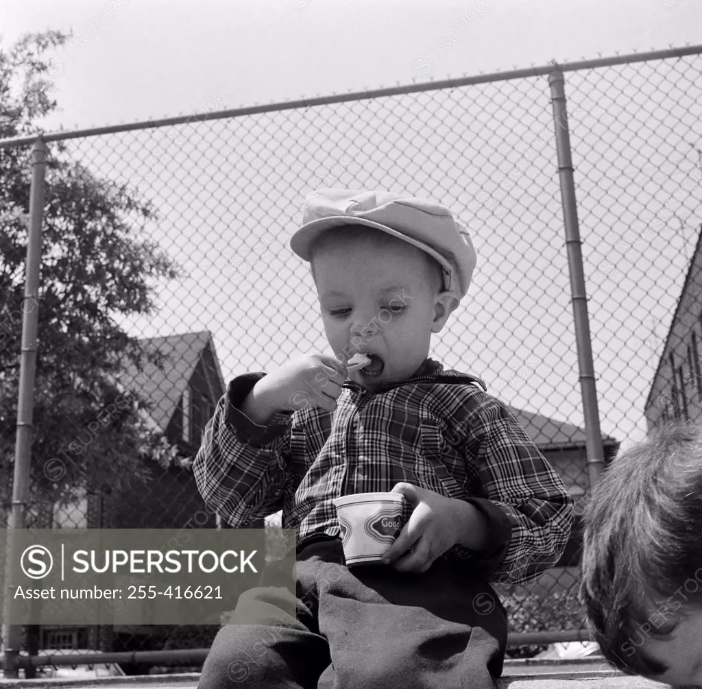 Boy sitting and eating ice cream