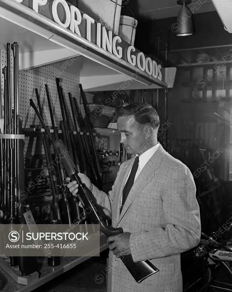 Man choosing airgun in shop