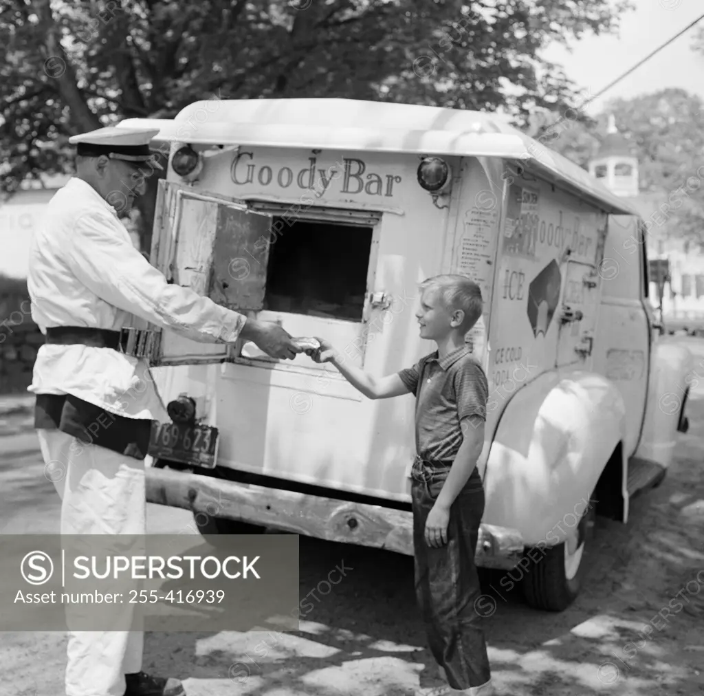 Boy buying ice cream from vendor