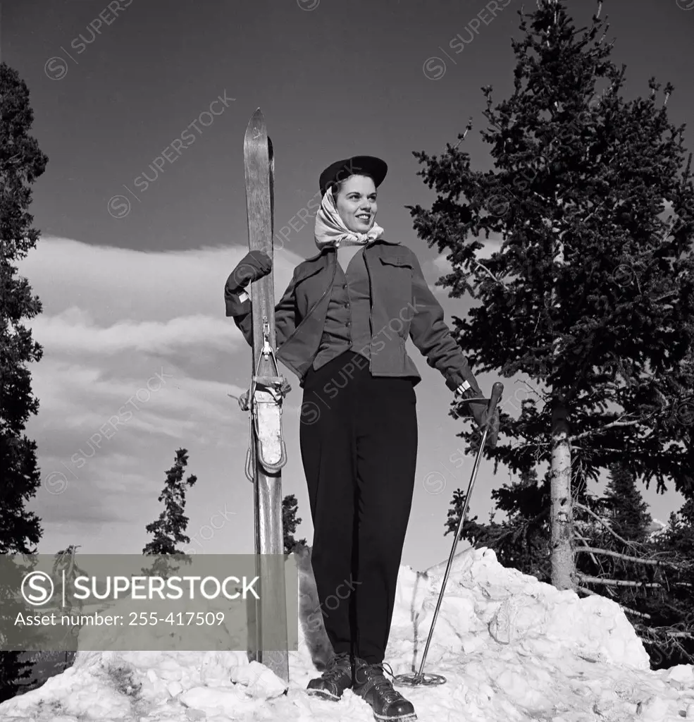 Woman holding skis and poles