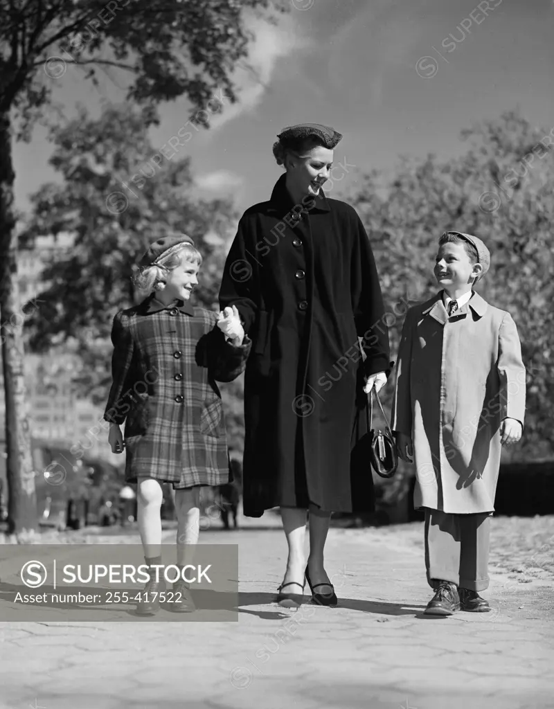 Mother with kids walking through park