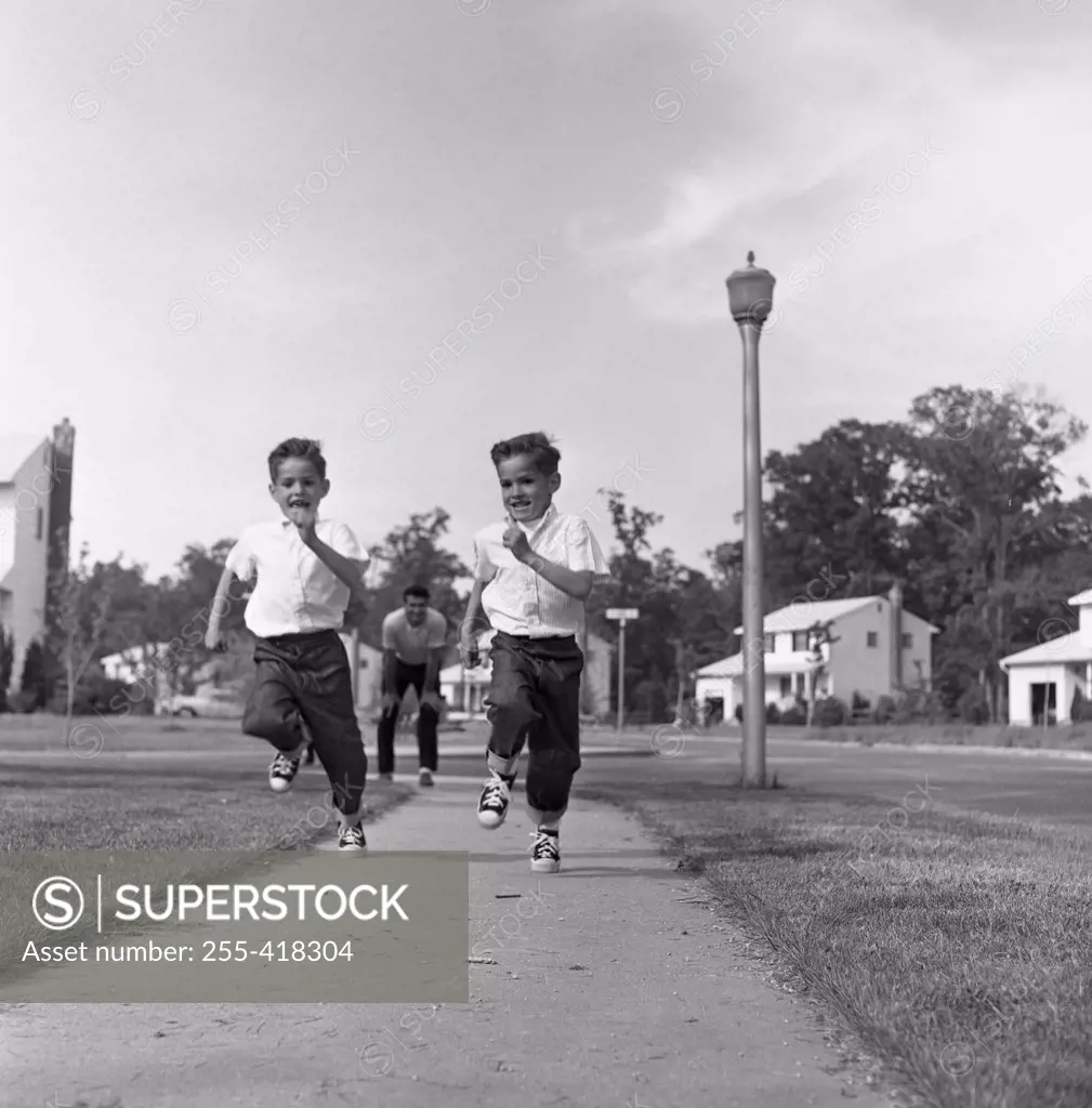 Twin boys running on pavement