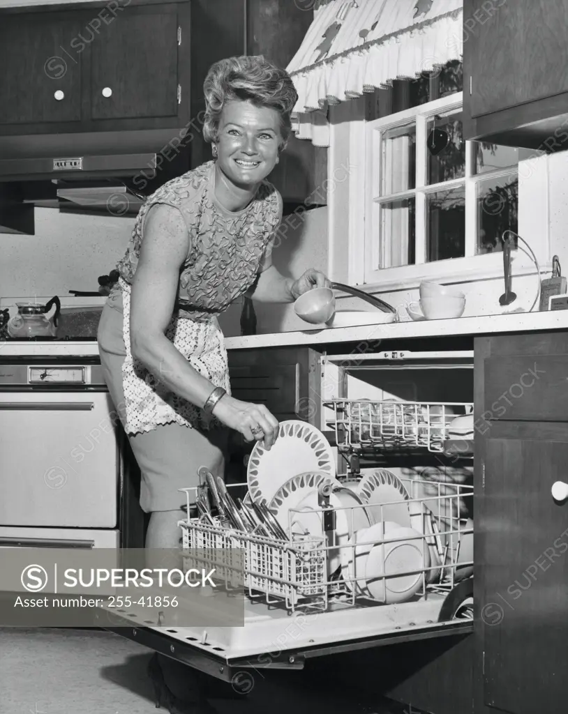 Portrait of a mid adult loading a dishwasher