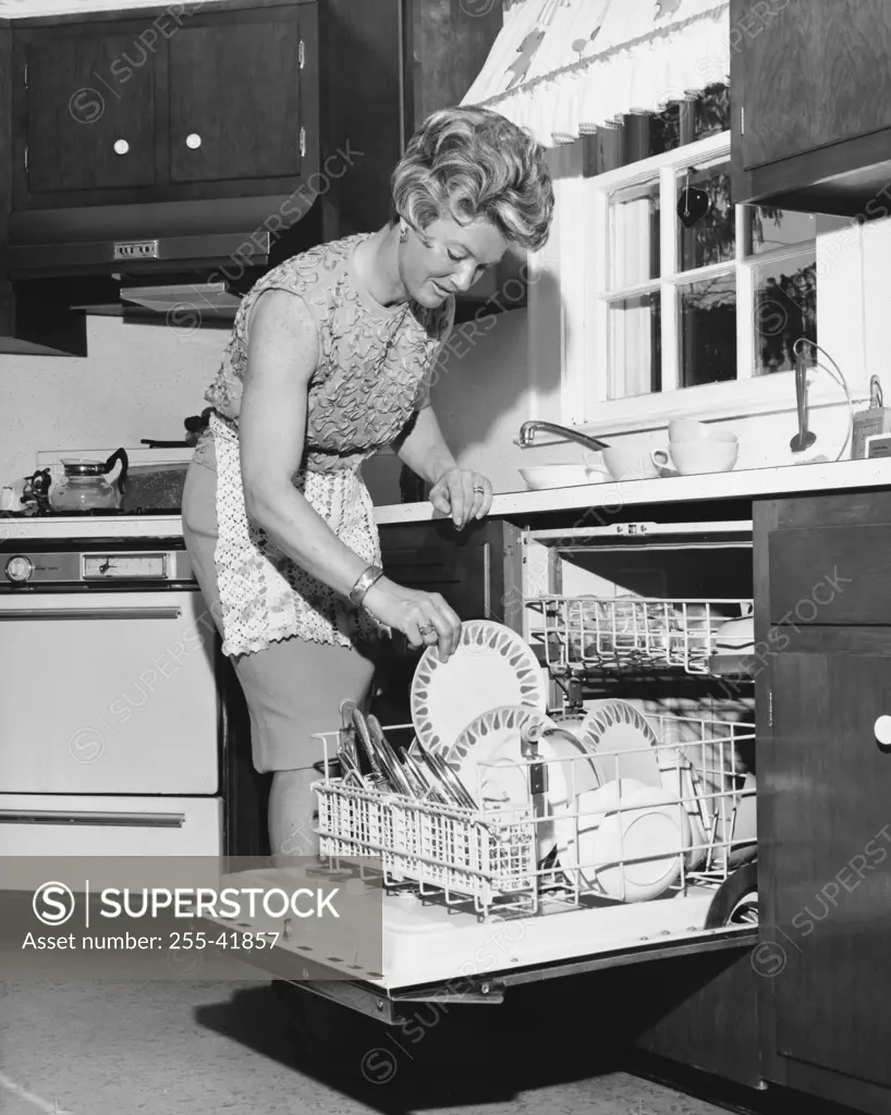 Mid adult woman loading a dishwasher