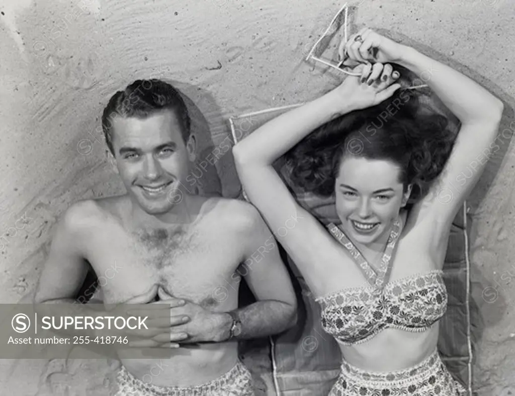 Overhead portrait of young couple relaxing on beach