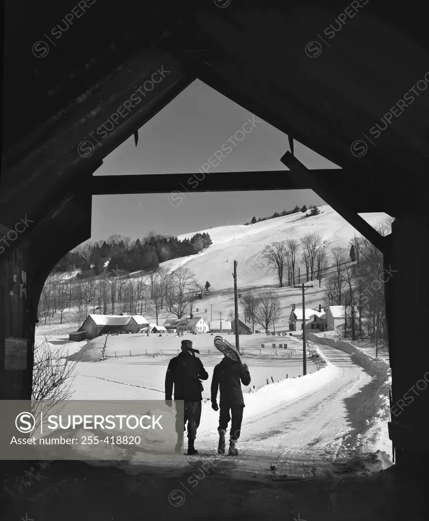 USA, New England, Vermont, Turnbridge, Men walking under covered bridge on Route 110