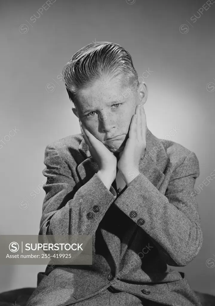 Portrait of worried teenage boy, studio shot