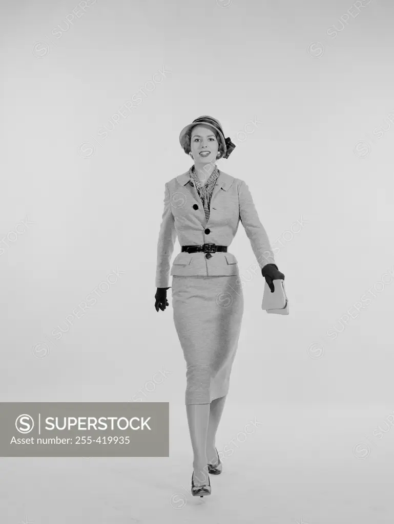 Portrait of elegant young woman walking, studio shot