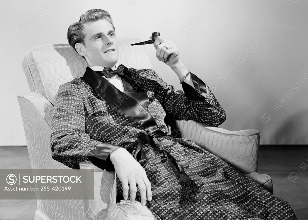 Man smoking pipe in armchair