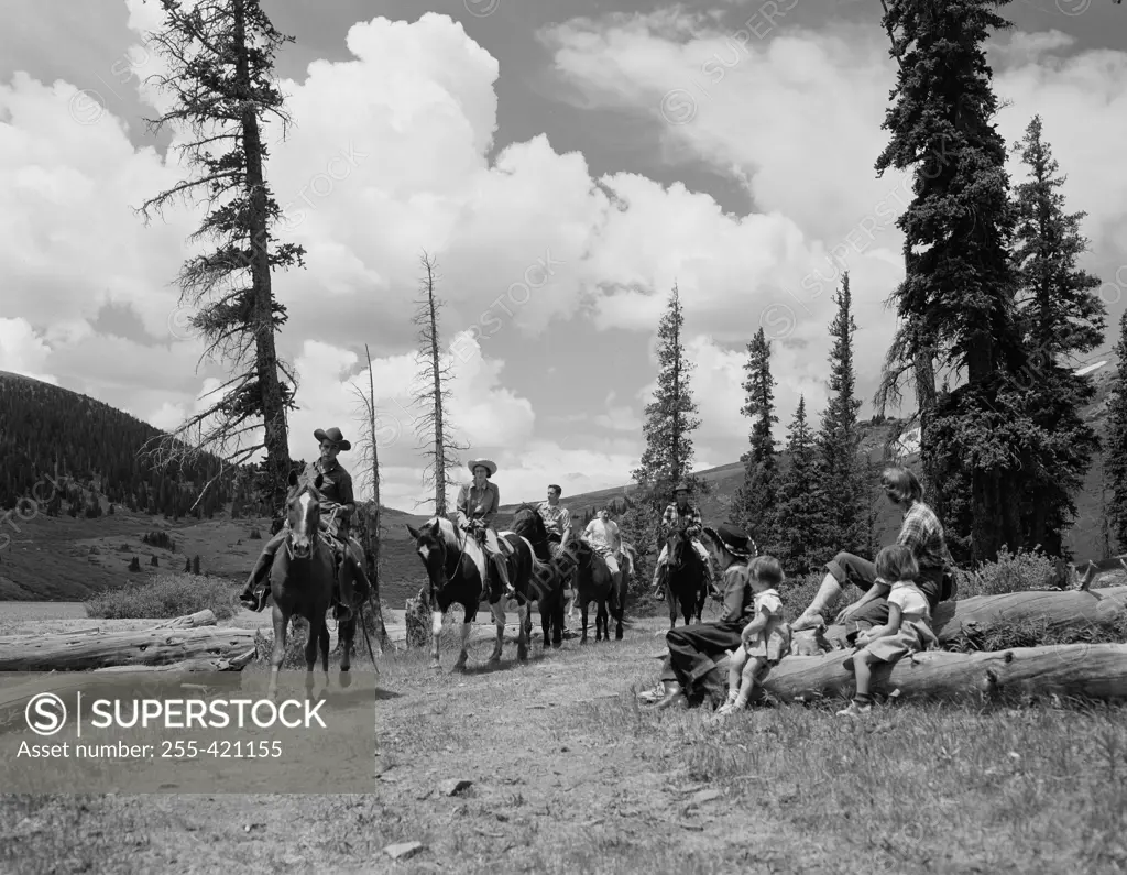 People horseback riding in hilly landscape