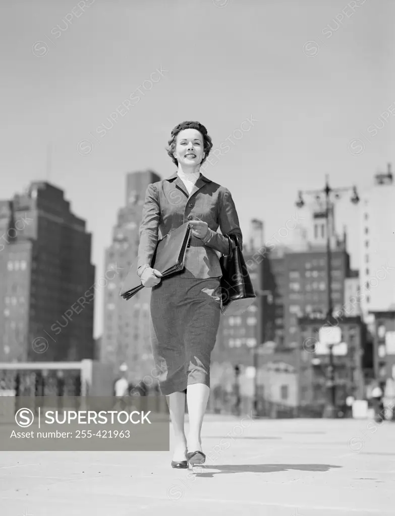 Cheerful businesswoman walking in downtown