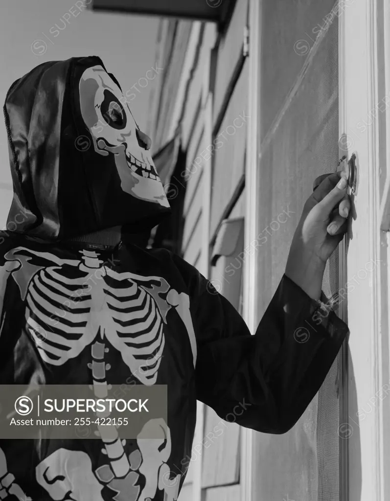 Person ringing doorbell wearing as skeleton