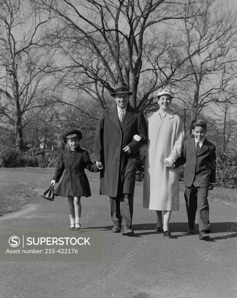 Portrait of family with two children walking in park