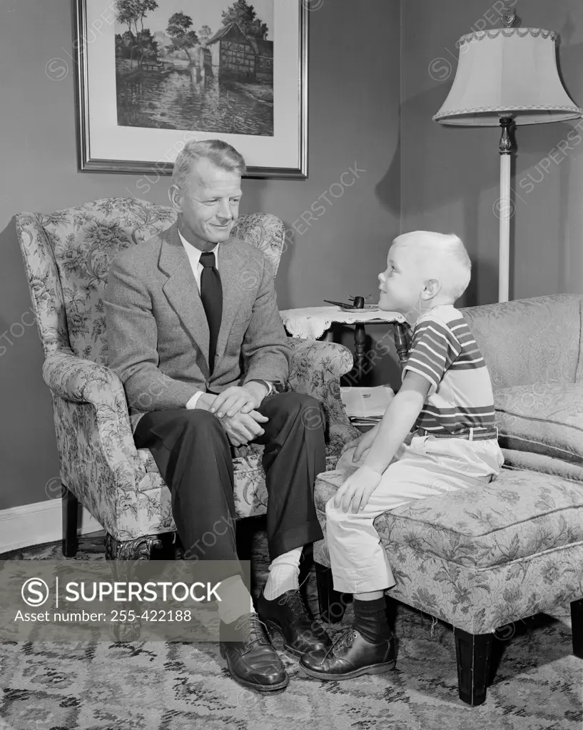 Boy sitting with grandfather in living room