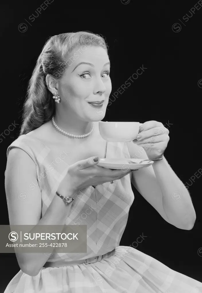 Studio portrait of young woman drinking tea.